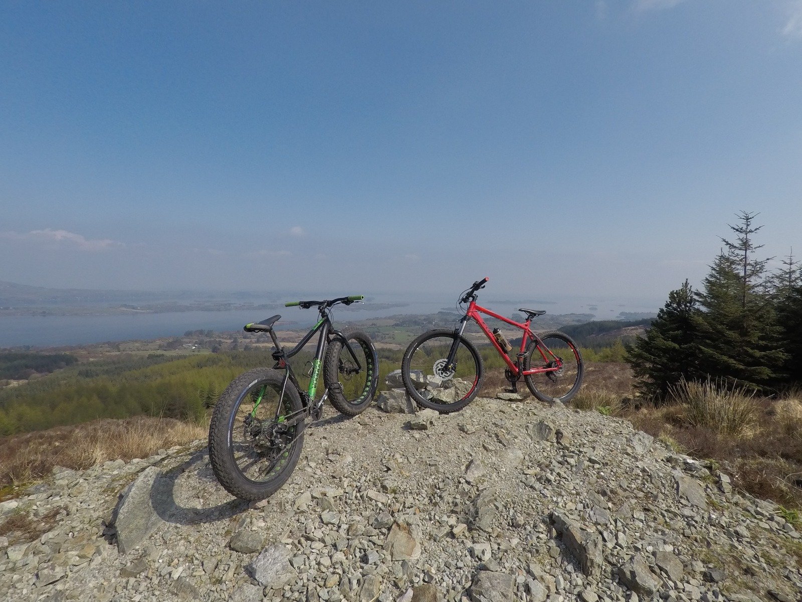 Two bikes facing each other on the top of  a  hill